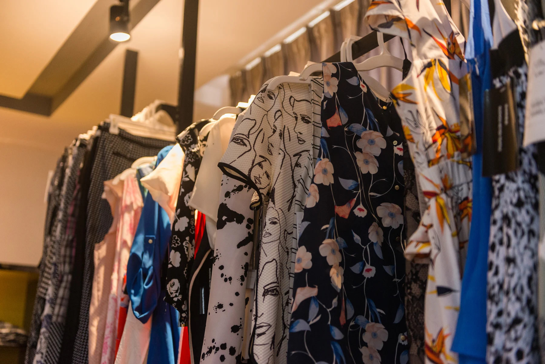 Floral and abstract print garments displayed on hangers