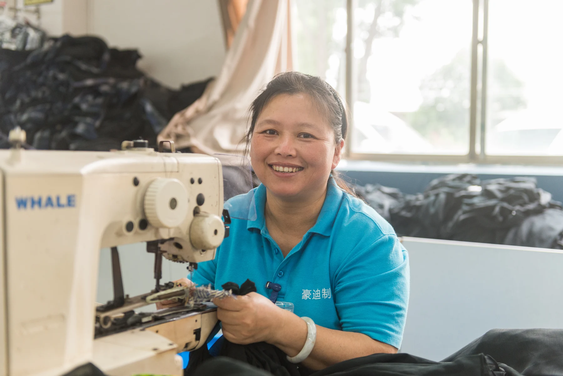 Garment worker seated at an industrial sewing machine