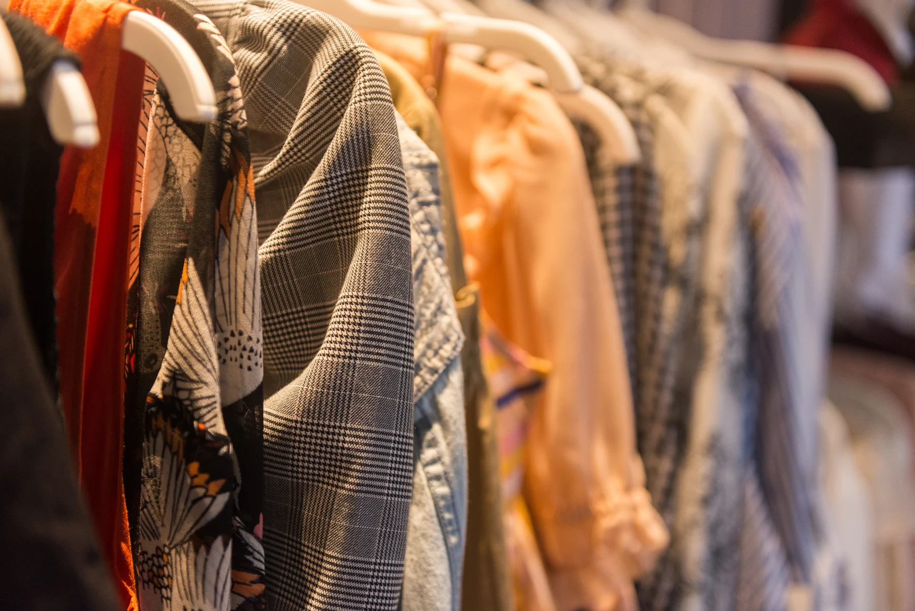 Checked and printed garment samples hanging on a clothing rail